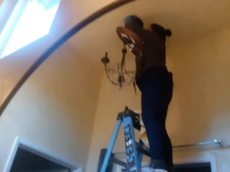 Electrician installing a chandelier in a Oberlin residence